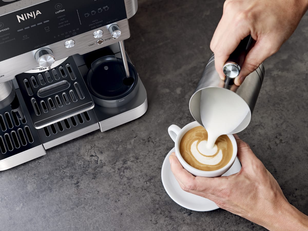 Pouring hand-frothed microfoam into freshly brewed espresso